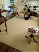 Full view of rug under living room furniture showing overall size and wear.