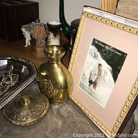 Photo showing brass vase, silver plated tray, silver plated container with lid, and framed picture with a family photo.