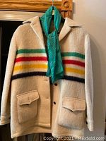 Front view of cream Hudson’s Bay wool coat with green, red, yellow and navy stripes and flap pockets