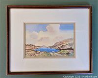 Framed watercolour landscape painting featuring hills, water, and sheep, signed by James McConnell.