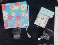 Assorted jewelry in gift boxes and black velvet earring holders, including ring and two sets of earrings.
