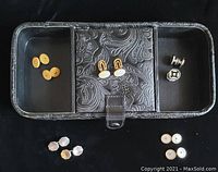 Photo showing five pairs of cufflinks arranged in a black faux leather jewelry holder with floral snap closure.