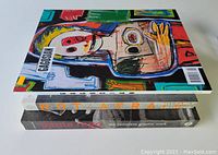 Stack of three large format softcover art books, spines visible showing titles and condition.