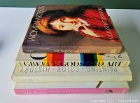 Stacked four large hardcover art books showing their spines and titles.