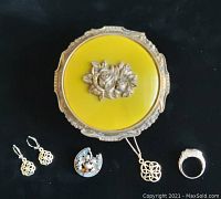 Photo shows the small vintage metallic green jewelry box with pewter rose on the lid and the jewelry items displayed below: earrings, brooch, pendant on chain, and ring.