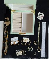 Open light green jewellery box with nine jewellery pieces and ruler showing box dimensions.