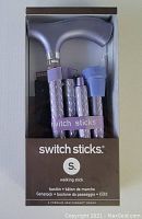 Photo of the new Switch Sticks folding walking stick packed in original box, showing lilac wood handle and folded shaft.