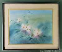 Framed view of the watercolour painting showing pink trillium flowers in soft blue and green background with signature and monogram stamp visible on the lower left.
