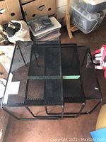 Set of three black perforated metal nesting tables arranged nested within each other, showing size progression and condition.