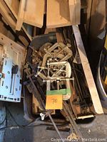 Bucket with multiple metal clamps including C-clamps and pipe clamps among some wood pieces.
