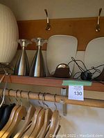 Shelf view with white paper lantern lamp, two brushed metal cone lights and partial magazine rack