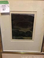 Framed limited edition landscape print in silver metal frame with white mat showing trees and hills
