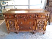 Front view of carved oak buffet sideboard with drawers, cabinet doors and brass-tone pulls
