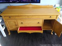 Solid oak bureau with two doors, central drawer lined with red felt, carved apron, Queen Anne legs.