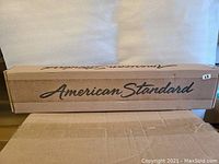 Box with American Standard branding containing the towel bar.
