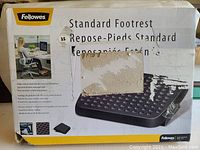 Box of Fellowes Standard Footrest with distressed and damaged packaging but item inside is new. Shows product image and features.