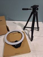 Ring light and tripod stand on a table with box underneath