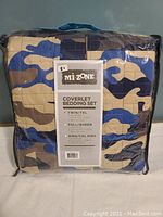Full package showing Mizone branding and camouflage blue coverlet pattern in a clear zippered plastic bag with handle.