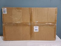 Photo of the unopened cardboard box packaging containing the door mat.