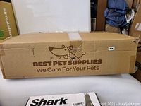 Cardboard shipping box labeled "BEST PET SUPPLIES We Care For Your Pets" with minor dent and tape seal, indicating original packaging for a pet tent bed.