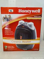 Box front showing Honeywell ceramic heater image and branding with family picture and product features.