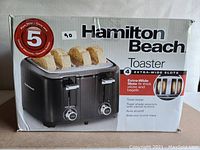 Box front showing Hamilton Beach branding, model features including 4 extra-wide slots, and 5-year warranty badge.