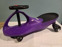 Side view of purple kids ride-on scooter showing black seat and front wheels