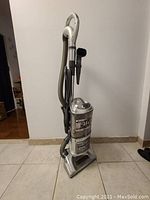 Shark Navigator vacuum cleaner upright with hose and accessories visible, showing general condition and heavy wear