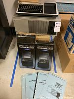 Full view of TI-99/4A computer along with peripheral expansion system, program recorders, and manuals on the floor.