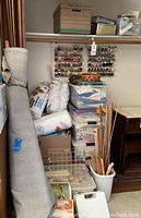 View of fabric tubs, bedding rolls, plastic bins and wooden spool racks mounted on wall