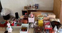 Photo showing multiple Japanese dolls, porcelain bowls, boxes with items, lacquered objects, carved wooden trivet, and decorative masks assorted on a table.