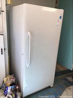 Front and left side view of freezer showing exterior condition in room.