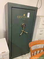 Closed front view of green Liberty Centurion safe showing electronic number pad, gold-tone tri-spoke handle and brand logo.