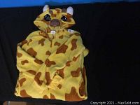 Giraffe costume laid flat showing front hood and sleeves with giraffe face details