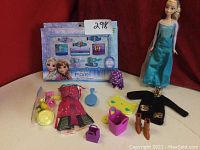 Full display of Elsa doll with accessories including dresses, boots, and boxed hair accessory set
