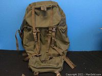 Front view of large olive green hiking backpack showing flap, straps and main body
