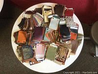 Top view of a wide assortment of leather and suede patches in various colors and patterns spread out on a round white table.