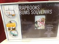 Front of the kit packaging showing two albums and 3 containers of scrapbooking accessories