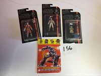 Three Star Wars Black Series figures and one Transformers coloring book laid flat on white surface.