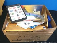 Box filled with envelopes, plastic bags, and a black folding magnifier