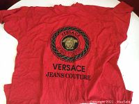 Full view of red T-shirt with Versace Jeans Couture logo and Medusa head emblem