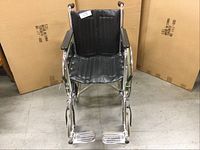 Front view of wheelchair showing padded seat and footrests.