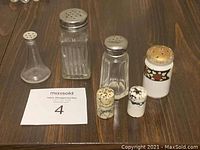 All six assorted salt and pepper shakers displayed on table showing different sizes, shapes and materials.