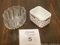 Photo showing two toothpick holders side by side on a wooden surface, with a MaxSold auction number card below.