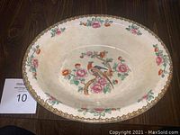Top view of oval vegetable bowl showing pheasant and floral decoration with yellow border rim.