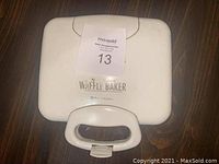 White exterior view of Toastmaster Waffle Baker showing handle and top lid with brand and product name.