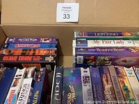 Box containing assorted VHS movies, showing titles like The Color Purple, Ghost Dad, Slave Trade, Lion King, My Fair Lady, Beauty and the Beast