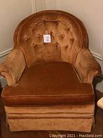 Front view of a vintage boudoir chair with button tufted velvet upholstery in brown color.