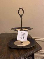 Two-tier Japanese tea tray with blue and white plates and metal handle, showing side angle