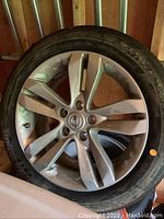 Front view of silver alloy wheel with Nissan center cap and mounted tire